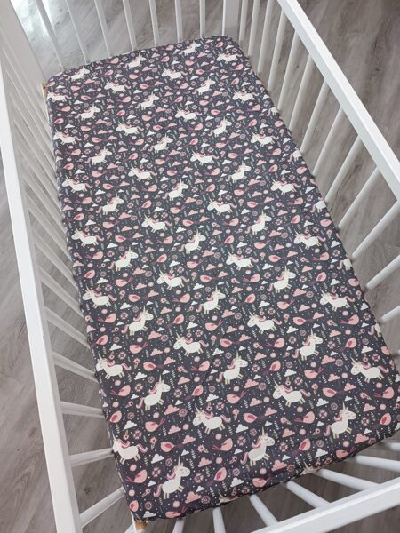 Gultas paladziņš - vienradži uz tumši rozā fona